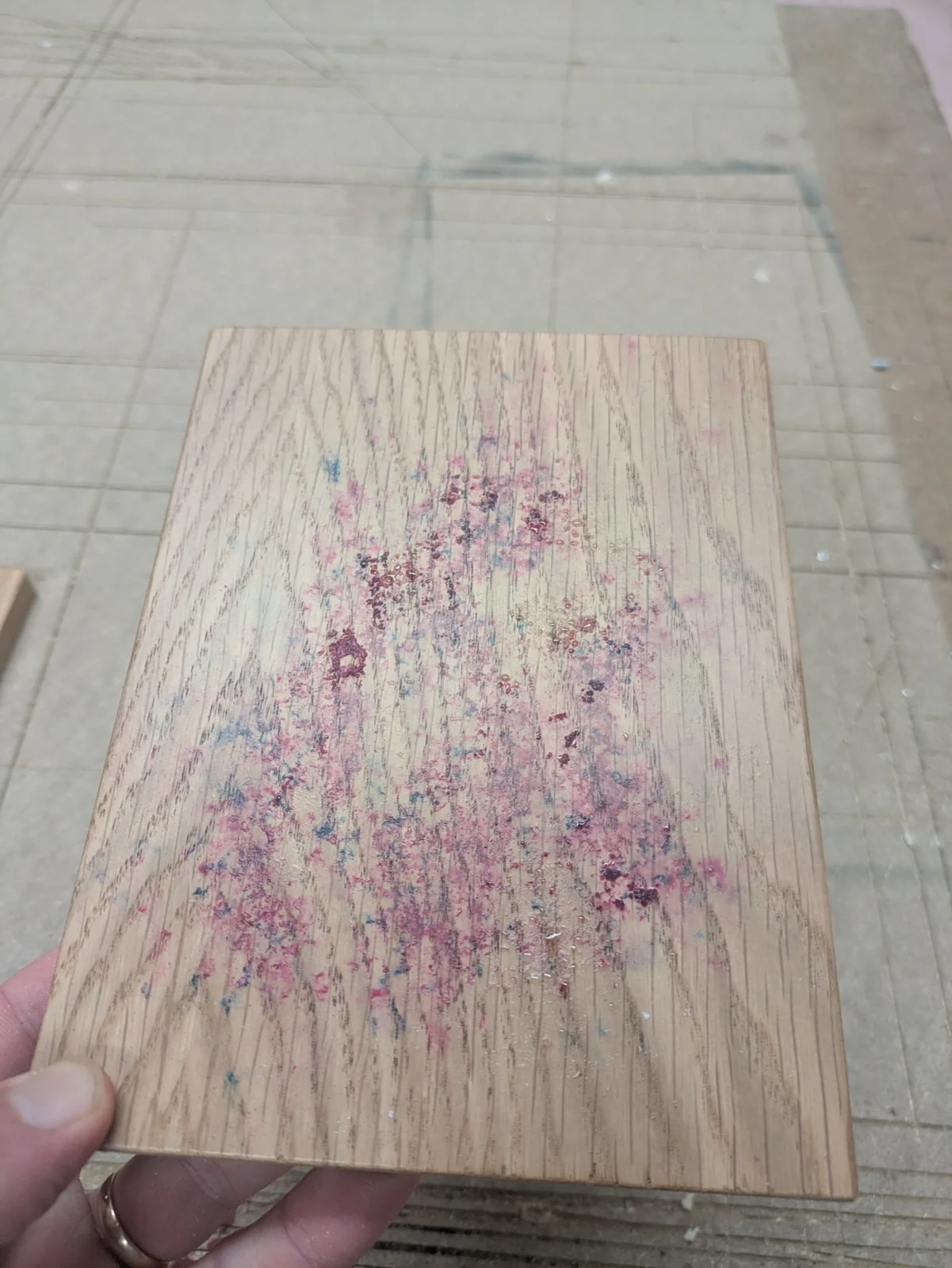 Pink and blue colour marks across a finished oak sample