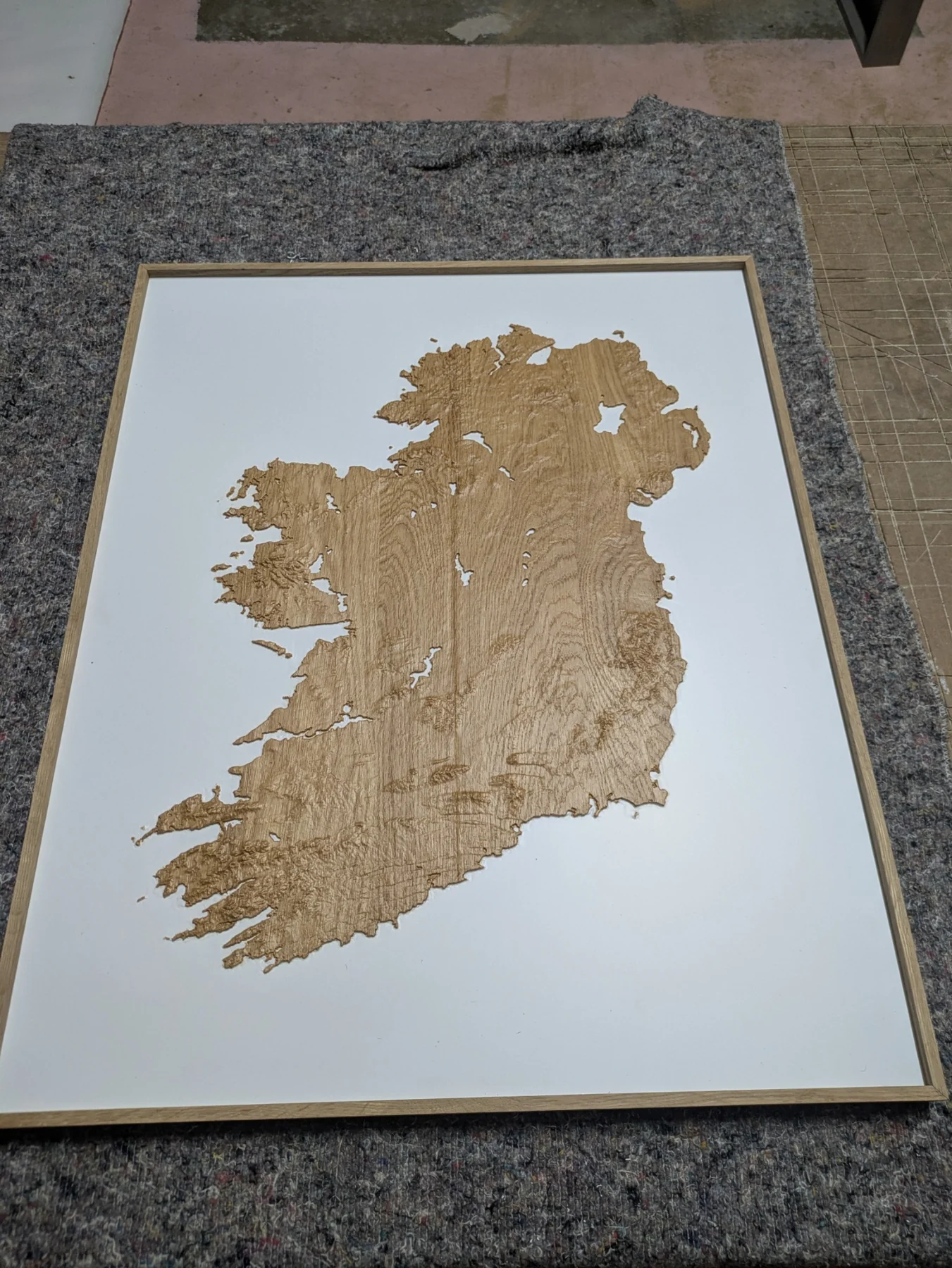Finished oak relief model of Ireland in a rectangular frame on the workshop bench
