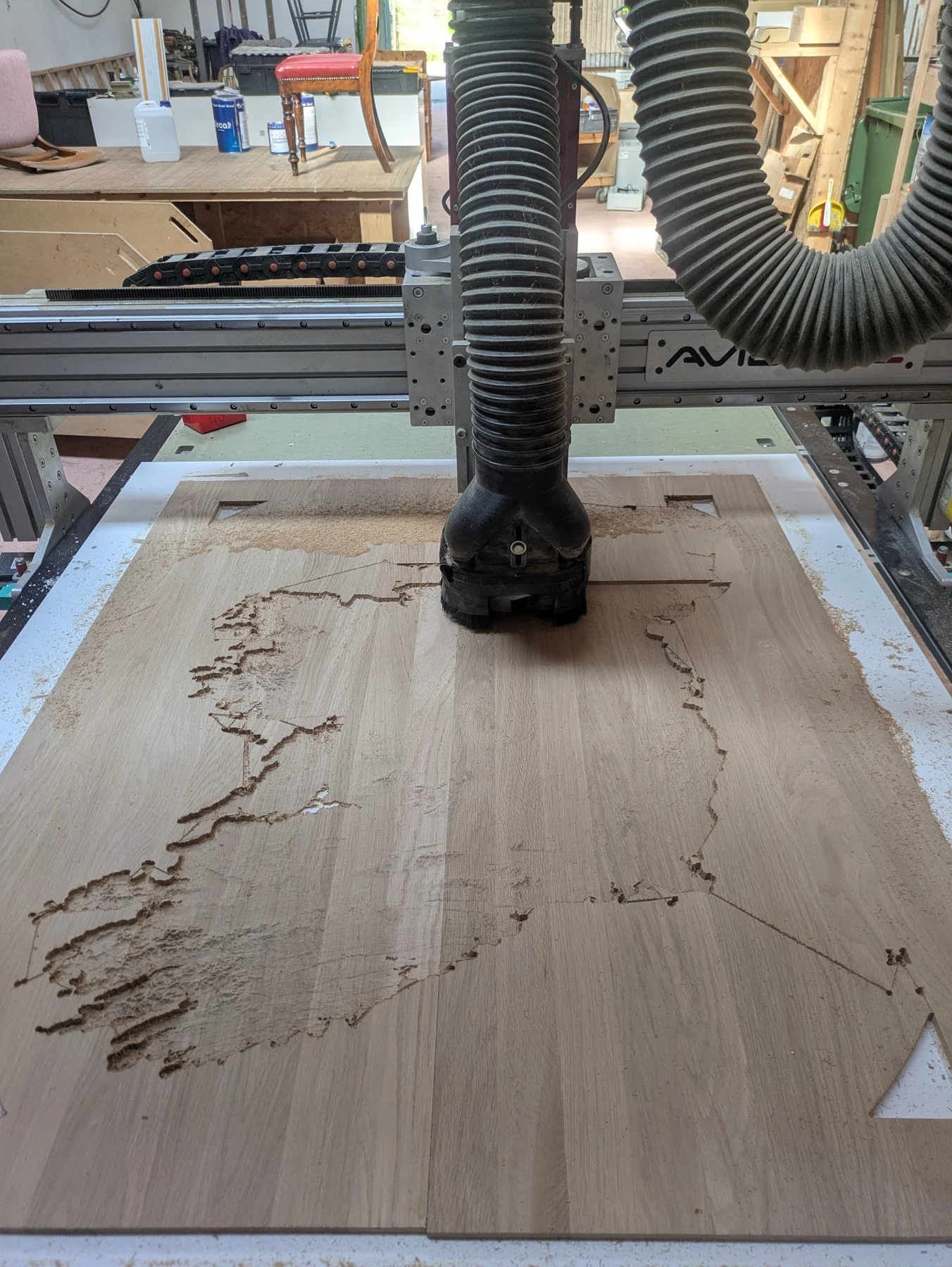 A CNC router machining Ireland in oak on a white backing