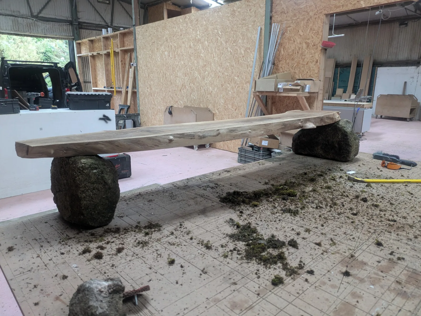The walnut board resting across two granite stones during setting out