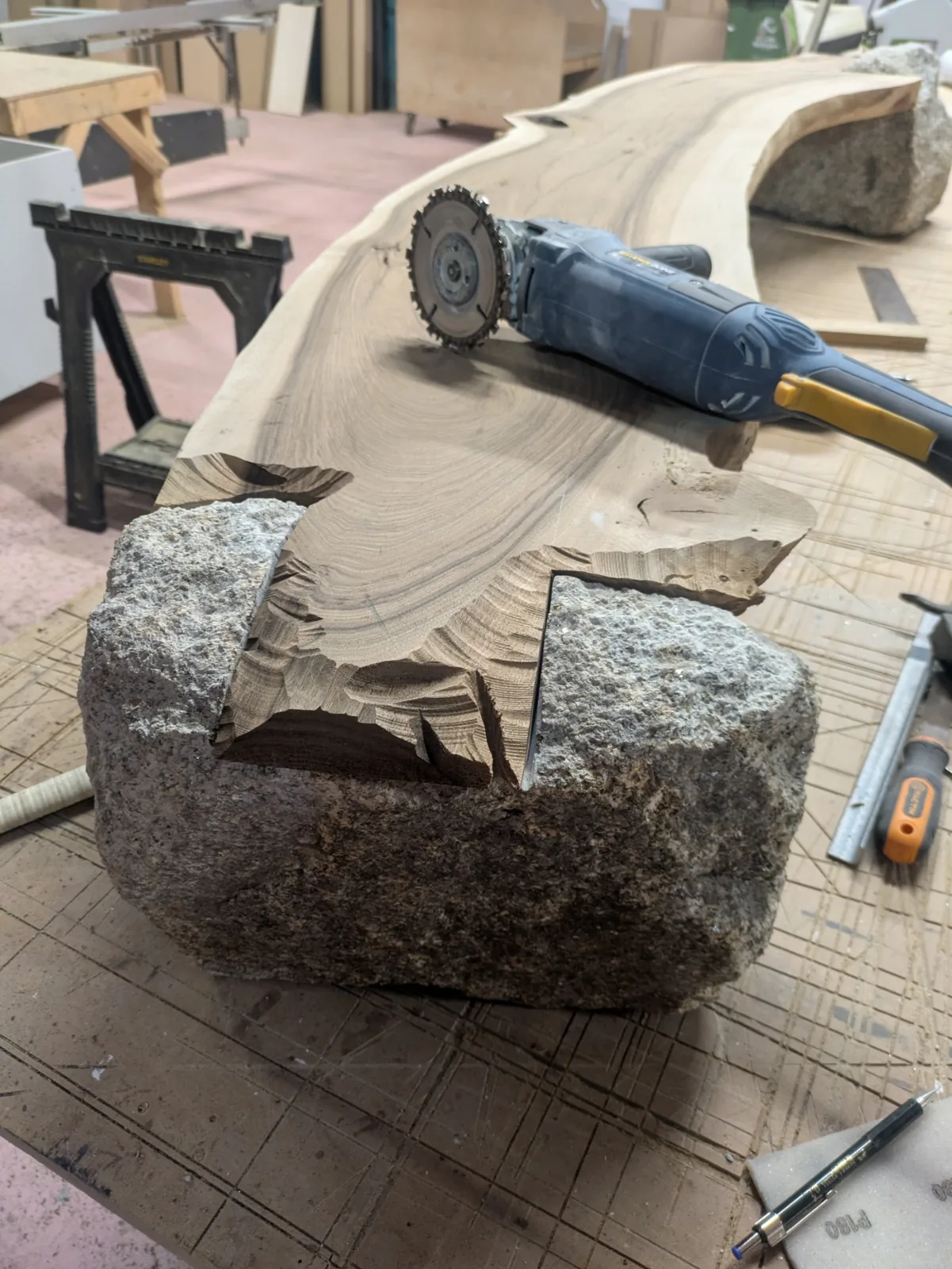 The walnut joint during shaping, with a power carving tool on the slab