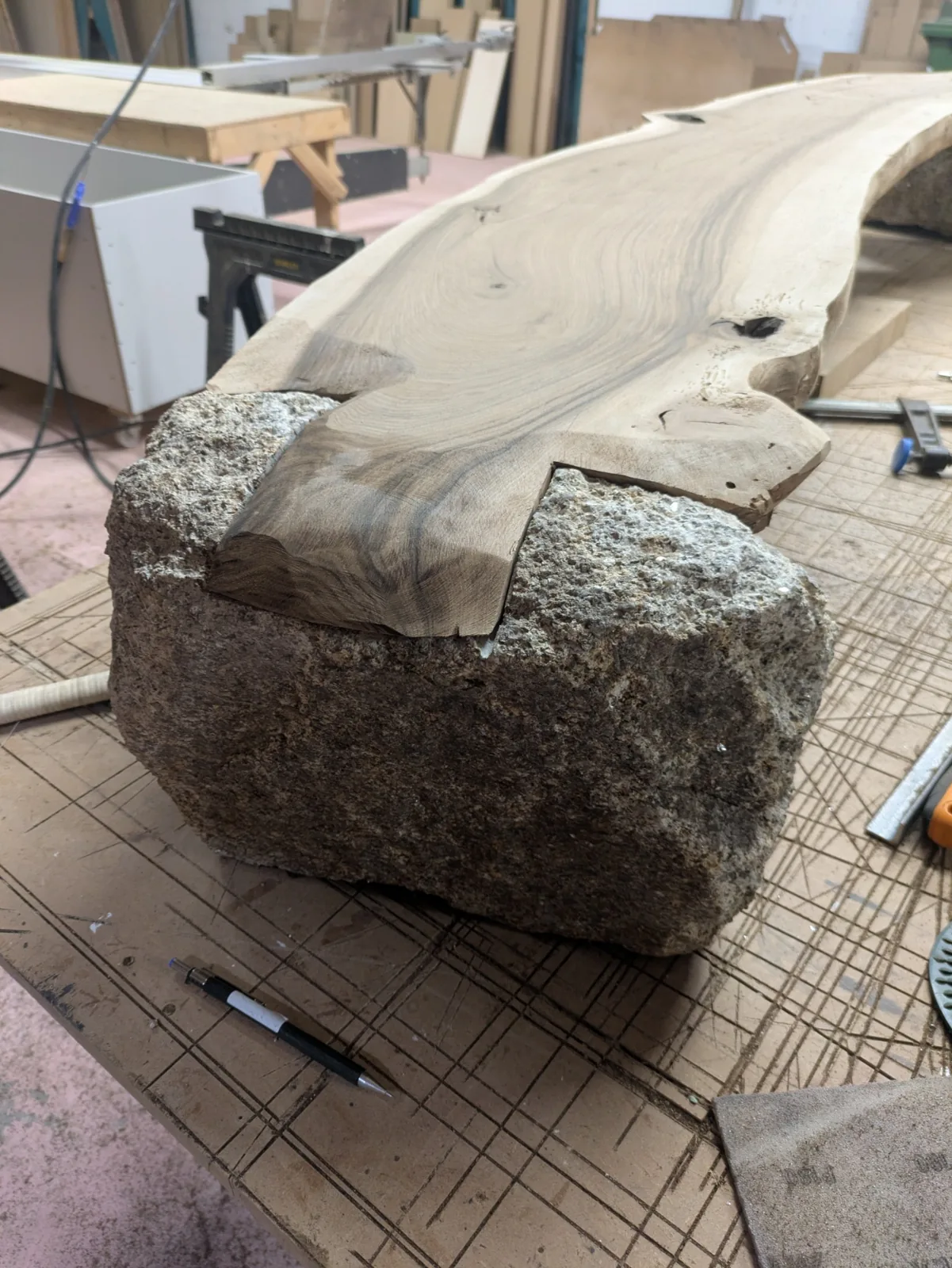 The walnut being shaped to follow the edges of its granite support