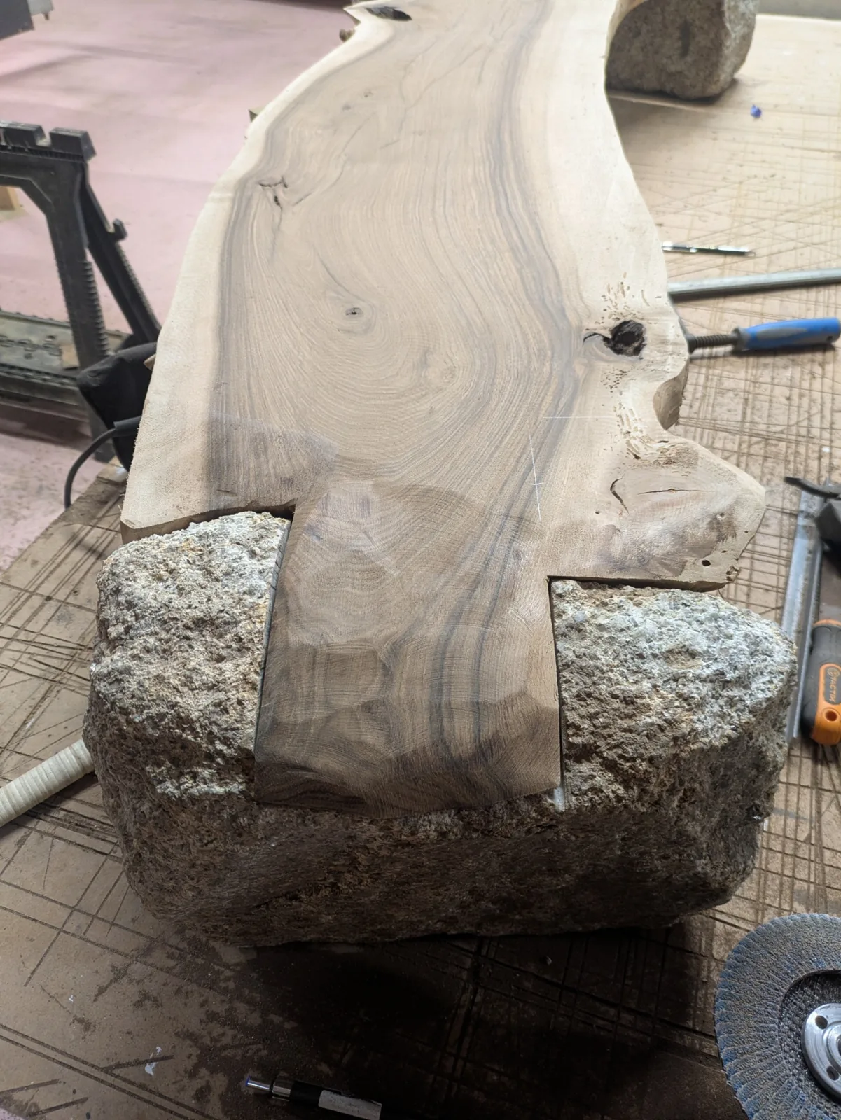 A close view of the walnut joint following the uneven edge of the granite
